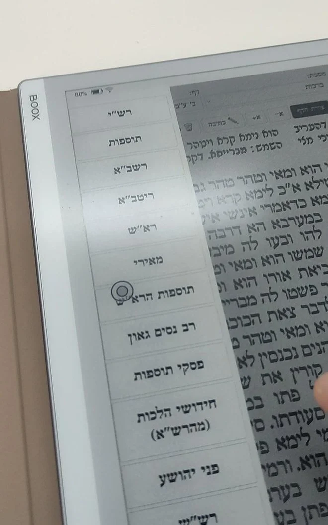רשימת המפרשים על הדף נפתחת לצד טקסט הגמרא, על מסך המכשיר